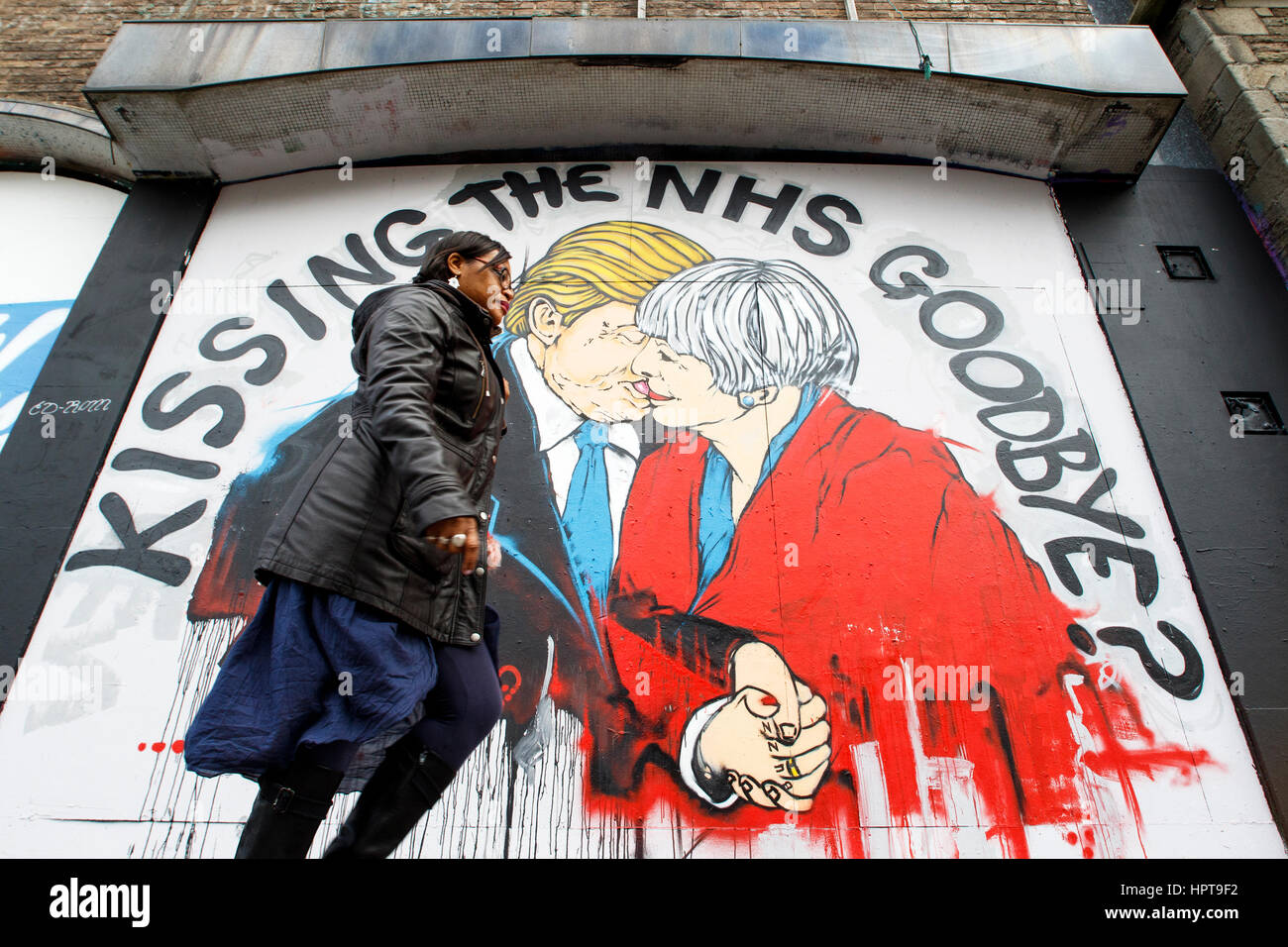 Bristol, UK. 24. Februar 2017. Eine Frau abgebildet ist, ein neues Stück von street Art Warnung über den Tod des NHS vorbeigehen. Das Kunstwerk erschien Teil des Protestes gegen Mittelkürzungen für die NHS "Speichern des NHS" in den letzten Tagen im Bereich Stokes Croft der Stadt. Das Bild zeigt Ministerpräsident Mai und Präsident Trump küssen und warnt davor, dass eine zu enge Beziehung zwischen den beiden Ländern nach Austritt das Ende des NHS ankündigen könnte. Bildnachweis: Lynchpics/Alamy Live-Nachrichten Stockfoto