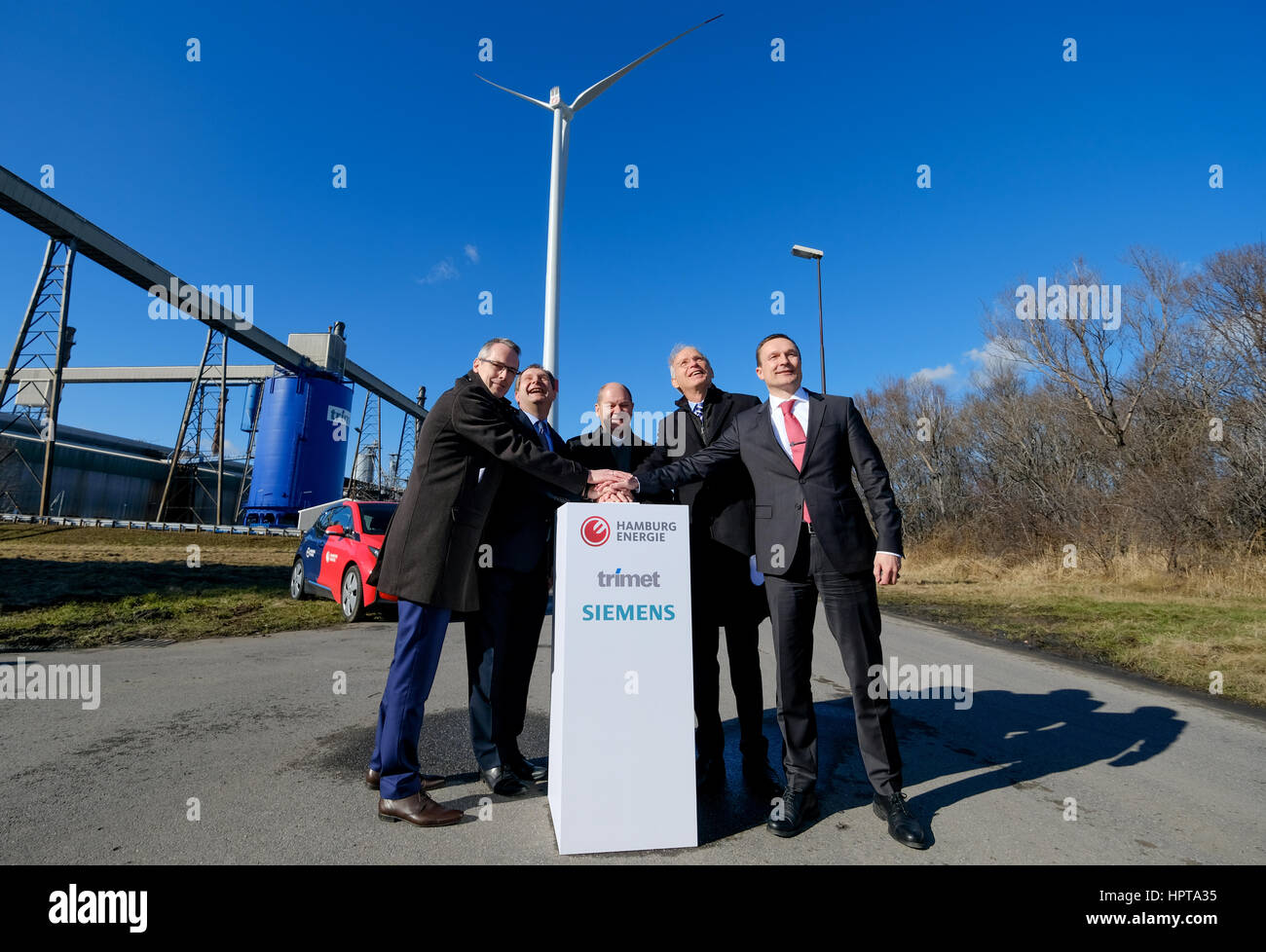 Hamburg, Deutschland. 24. Februar 2017. Siemens AG Vertreter Gunnar Liehr (L-R), Hamburgs Umgebung Senator Jens Kerstan (die grünen), Hamburgs Bürgermeister Olaf Scholz (SPD), der CEO von Hamburg Energie Michael Beckereit und Martin Iffert, CEO von Aluminium Sorge Trimet, drücken Sie einen großen Knopf zum Starten einer neuen Windenergieanlage in Hamburg, Deutschland, 24. Februar 2017. Die Wind-Energie-Türme sind 113 Meter hoch - einen Meter höher als die neue Elbphilharmonie Gebäude der Stadt. Foto: Axel Heimken/Dpa/Alamy Live News Stockfoto