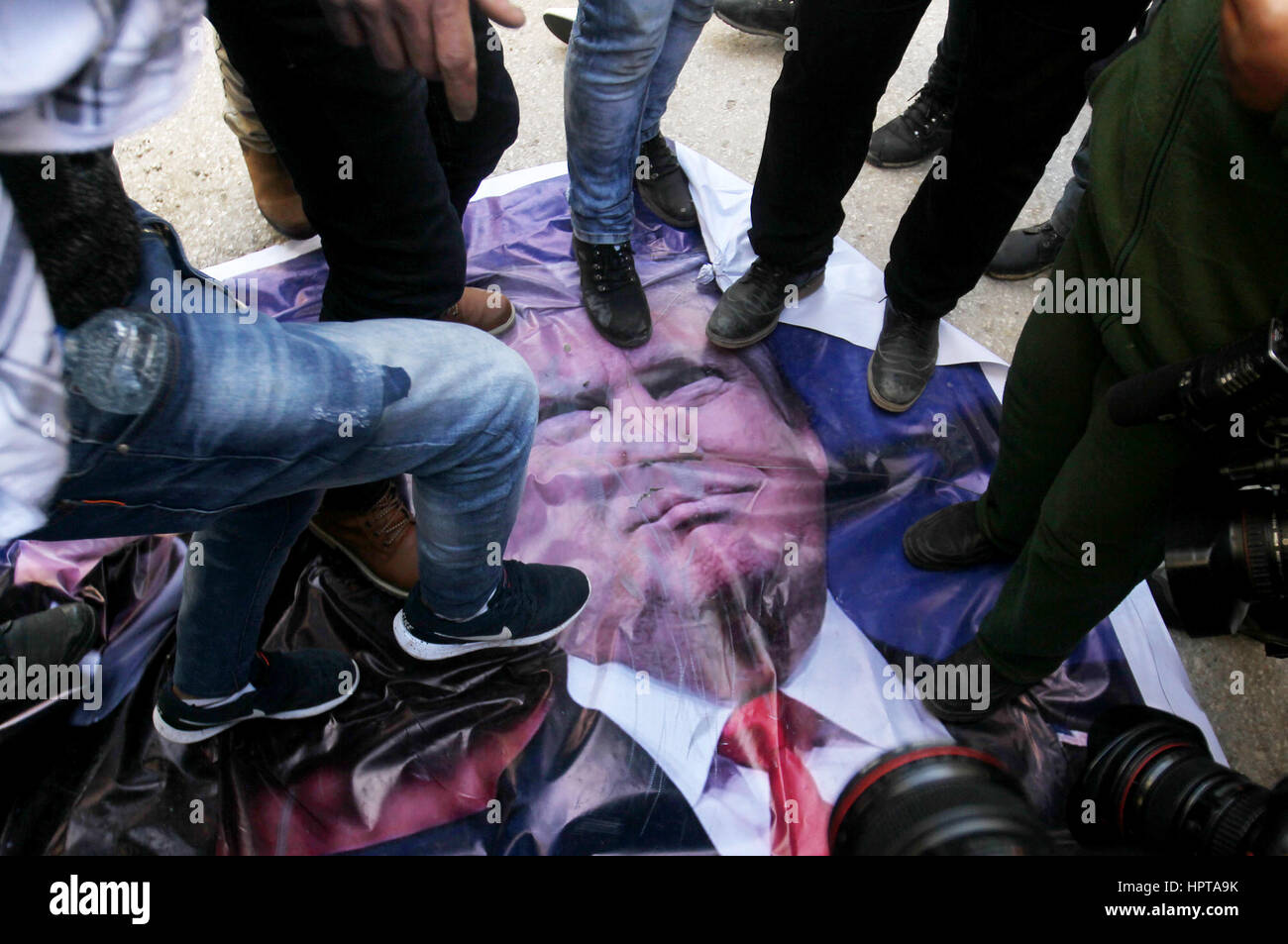 Hebron, Westjordanland, Palästinensische Gebiete. 24. Februar 2017. Palästinensische Demonstranten Schritt auf einem Plakat von US-Präsident Donald Trump wie sie protestieren gegen seine Unterstützung für Israel und die Nachfrage für die israelische Armee Shuhada Straße, wieder zu öffnen, die weitgehend für Palästinenser gesperrt ist, in der West Bank von Hebron am 24. Februar 2017 Credit: Wisam Hashlamoun/APA Bilder/ZUMA Draht/Alamy Live News Stockfoto