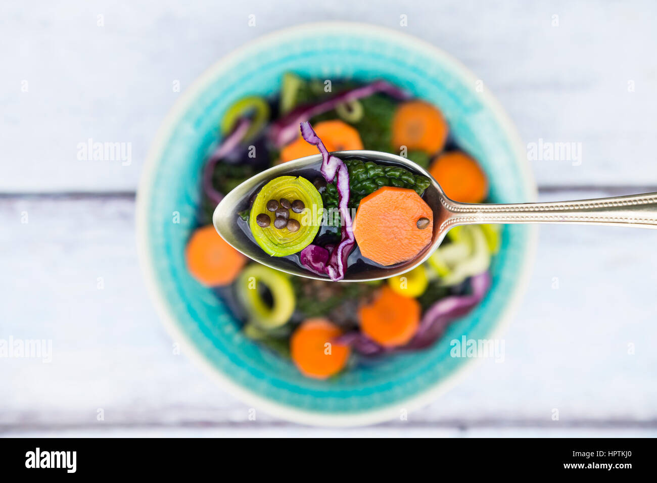 Löffel von Vegan-Kohl-Eintopf mit Linsen auf Holz Stockfoto