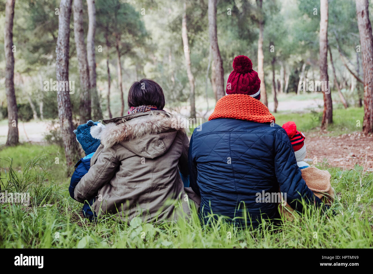Rückansicht der Familie sitzt im Wald Stockfoto