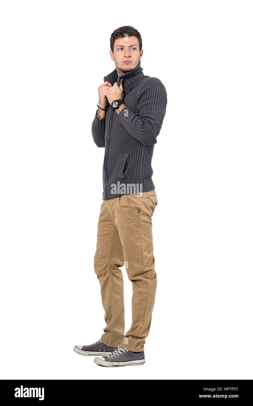 Seitenansicht des lässig junger Mann Pullover Kragen Blick hinter anpassen. Ganzkörper-Länge-Porträt isoliert auf weißem Hintergrund. Stockfoto
