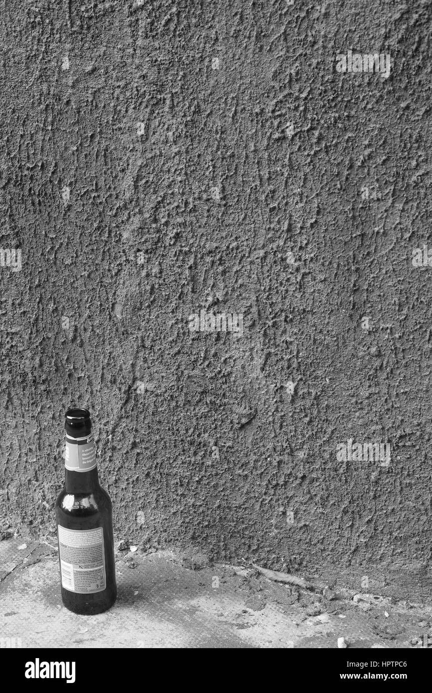 Leere Flasche gegen eine Wand Stockfoto
