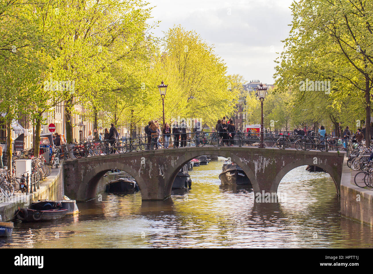 AMSTERDAM, Niederlande - 20. April 2015: Touristen auf der Brücke über den Kanal in Amsterdam, die Hauptstadt der Niederlande Stockfoto