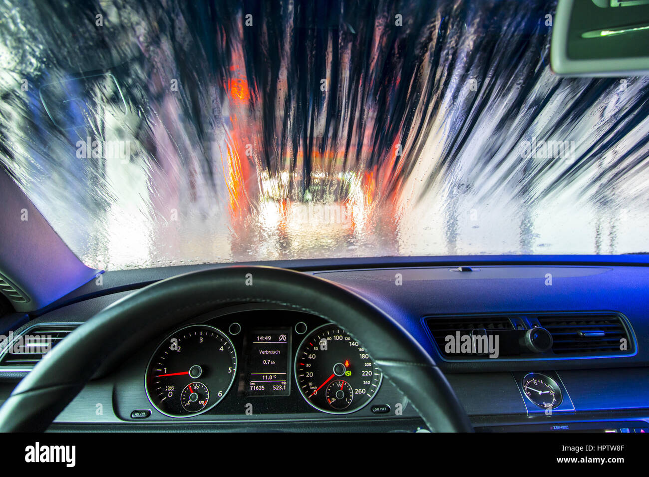 Mietwagen in einer automatischen Waschanlage-Site, Reinigungsschaum, versprüht rotierende Reinigungsbürste, Stockfoto