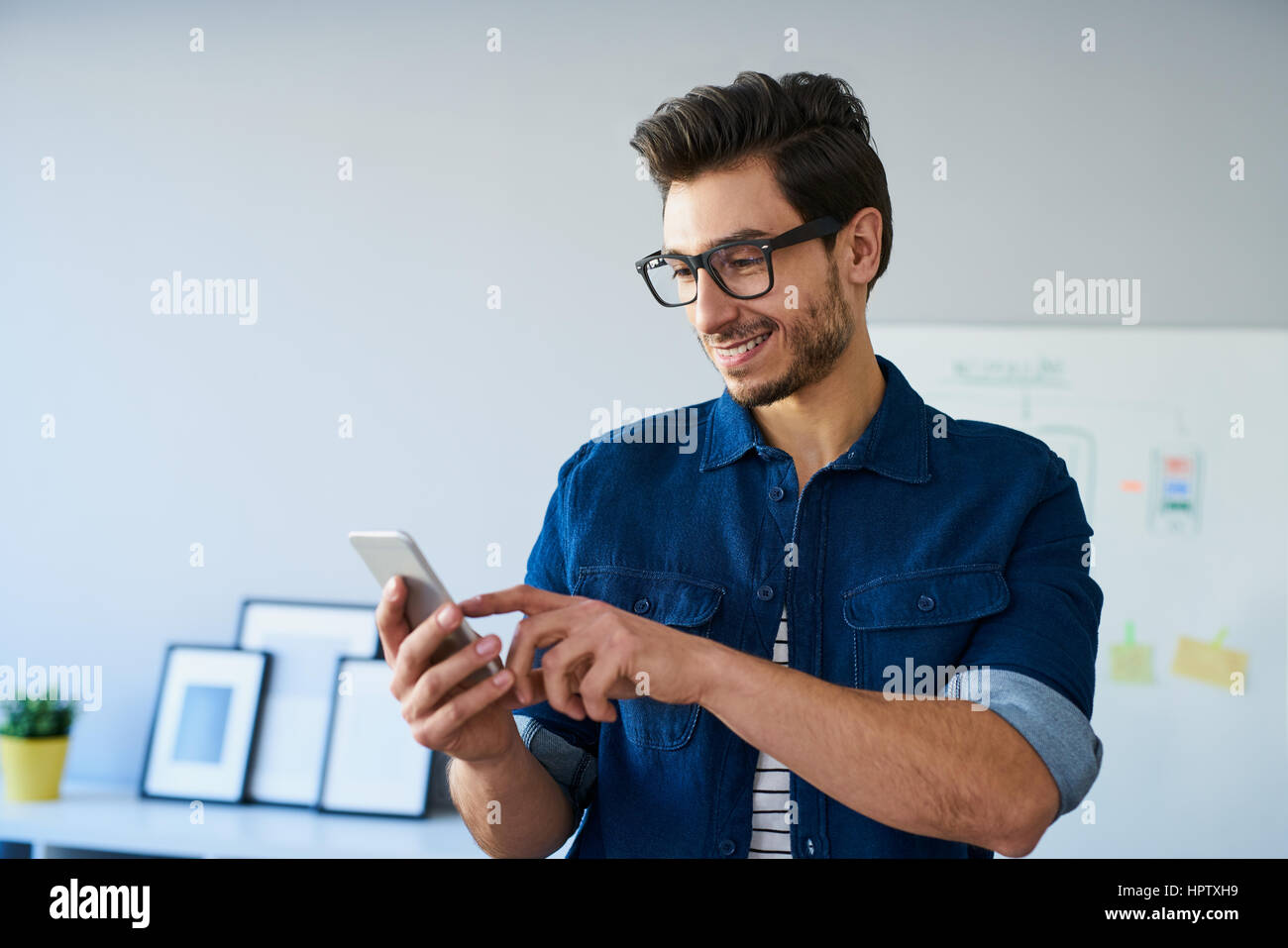 Glücklich Web Designer, Freiberufler mit Smartphone, home-Office arbeiten Stockfoto