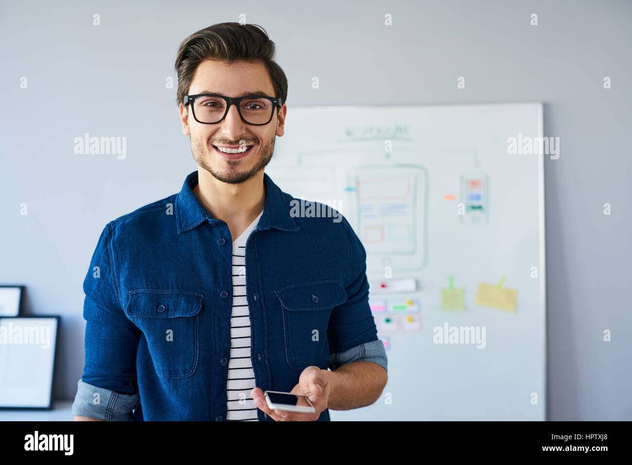 Porträt von glücklich Webdesigner, stehend im Büro neue ansprechende Website zu entwickeln. Stockfoto