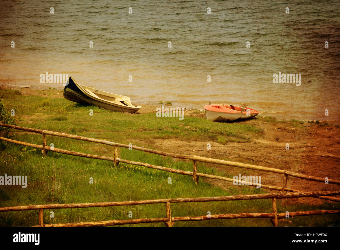 zwei Boote und Holzzaun im Strandbad, Vintage Grunge-Stil Stockfoto