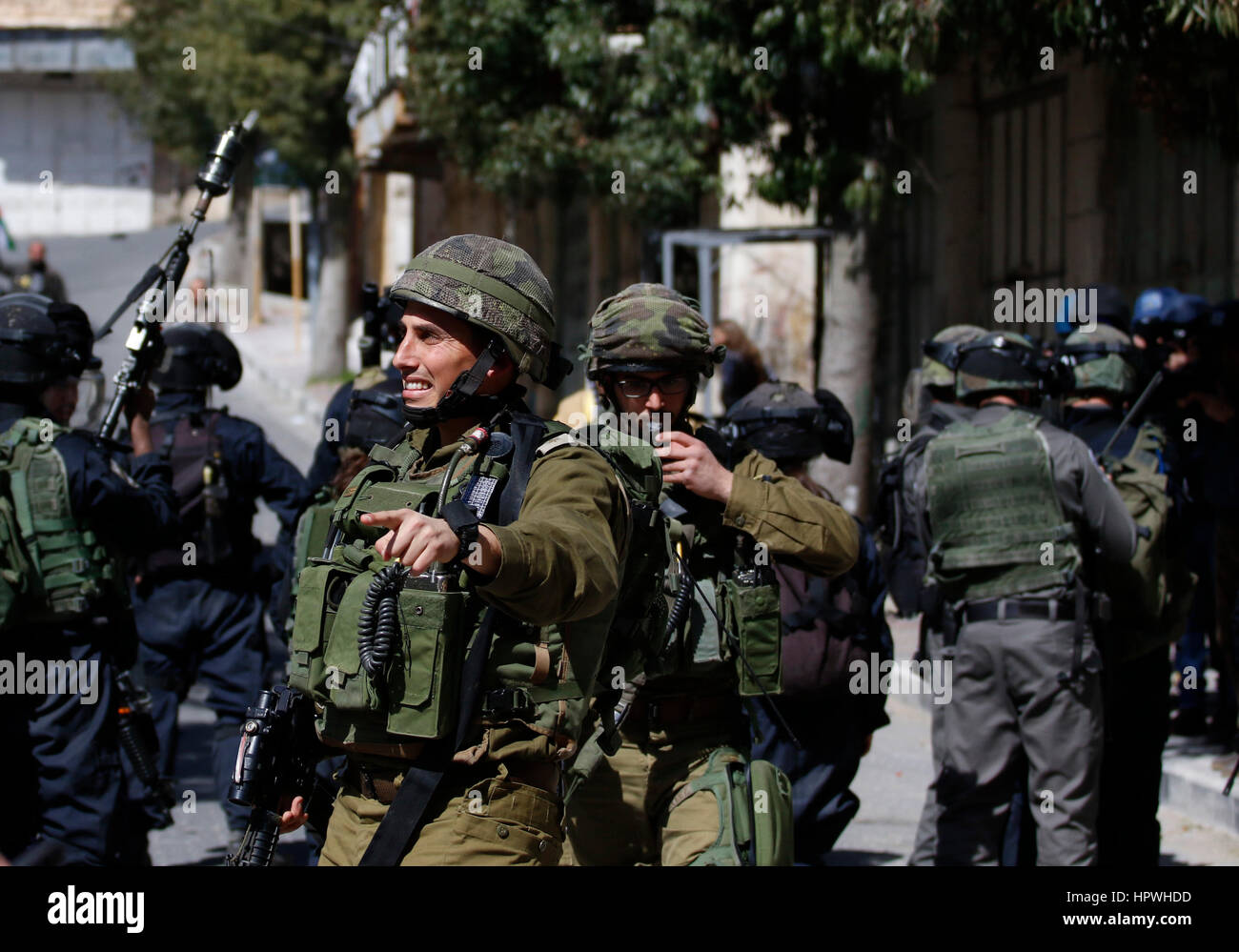 Hebron, Palästina. 24. Februar 2017. Eine israelische Armee Soldat Gesten während einer Protestaktion in der Altstadt von der West Bank von Hebron, 24. Februar 2017. Palästinenser protestierten gegen die Schließung der Shuhada Straße, die durch das israelische Militär geschlossen ist, seit 1994 und Bemerkung der kommenden 23. Jahrestag des Ibrahimi Moschee Massakers wo ein israelischer Siedler geschossen und tötete 28 Palästinenser während Morgengebet des Ramadan-Monats im Inneren der Moschee. Bildnachweis: Osama Qawasmi/Pacific Press/Alamy Live-Nachrichten Stockfoto