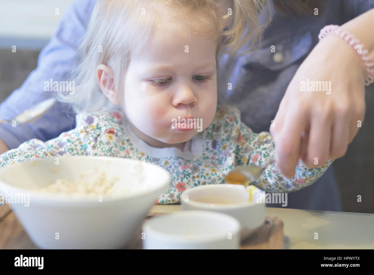 Mutter füttert Brei ihr Kind mit einem gesunden Frühstück Stockfoto