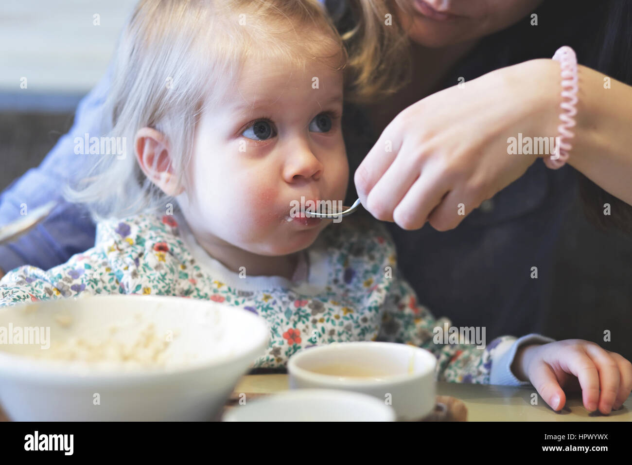 Mutter füttert Brei ihr Kind mit einem gesunden Frühstück Stockfoto