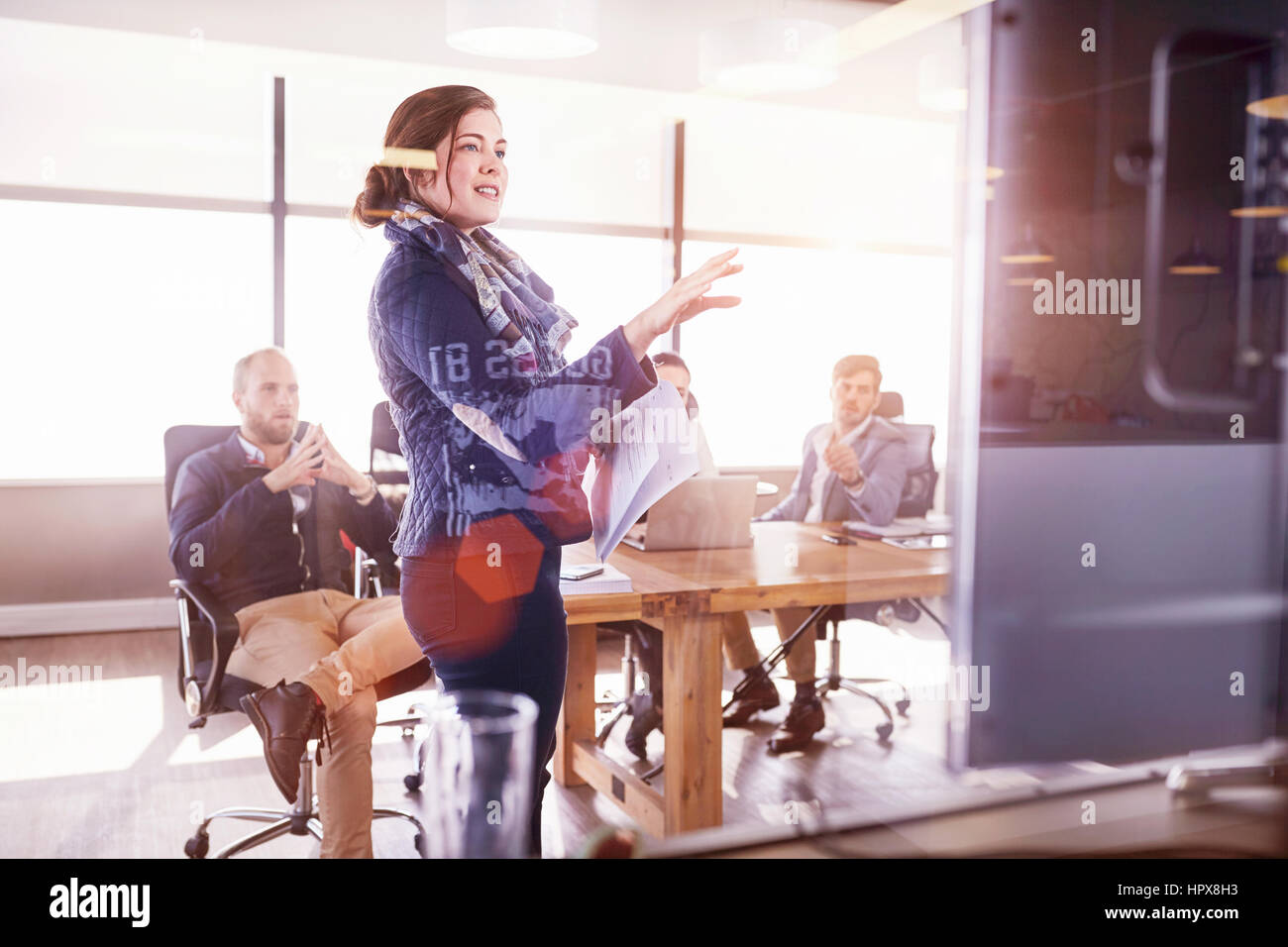 Geschäftsfrau, die führende Treffen am Fernsehschirm in sonnigen Konferenzraum Stockfoto