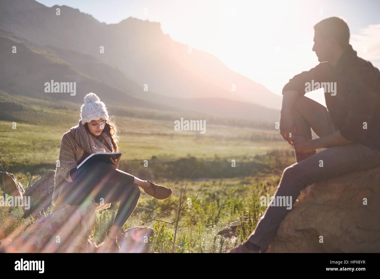 Junges Paar, Wandern, ausruhen und schreiben in sunny remote Feld Stockfoto