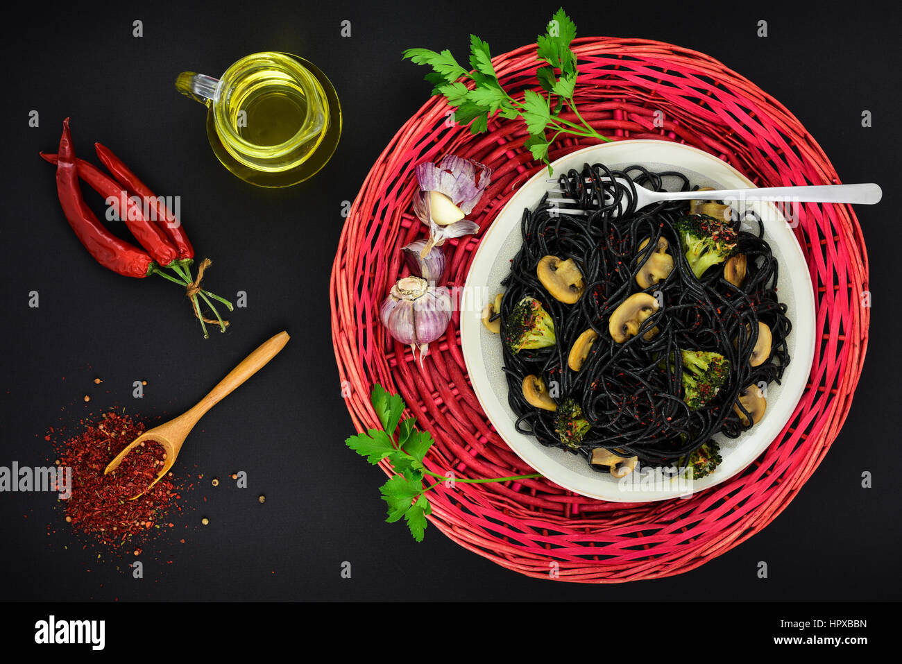Spaghetti, Knoblauch, Gewürze, Olivenöl und Chili auf dunklen Grunge Hintergrund, Ansicht von oben. Stockfoto