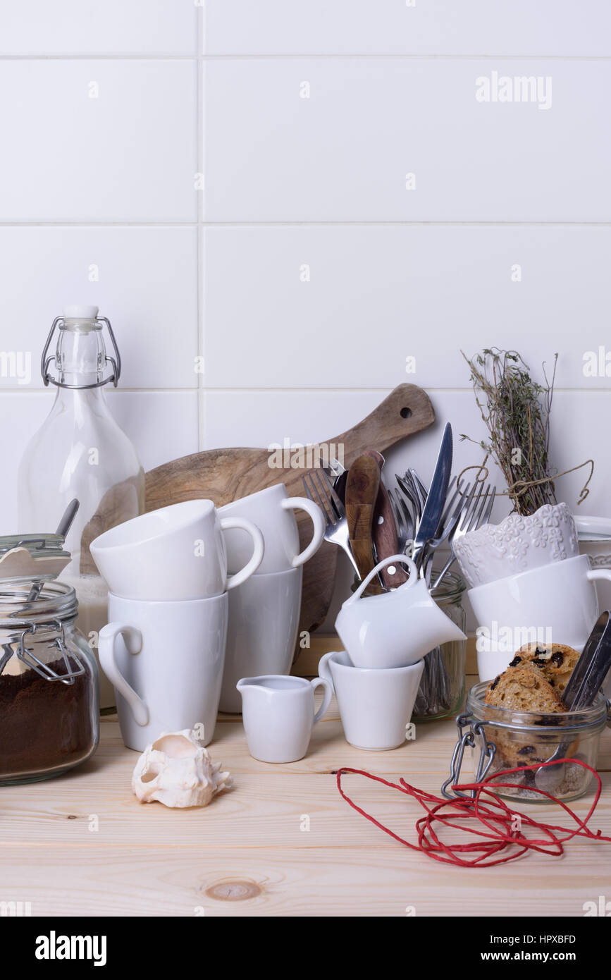 Stillleben mit Geschirr, Rohrzucker, Kekse, gemahlener Kaffee, Milch auf Holztisch. Kopieren Sie Raum, weißen Hintergrund. Stockfoto