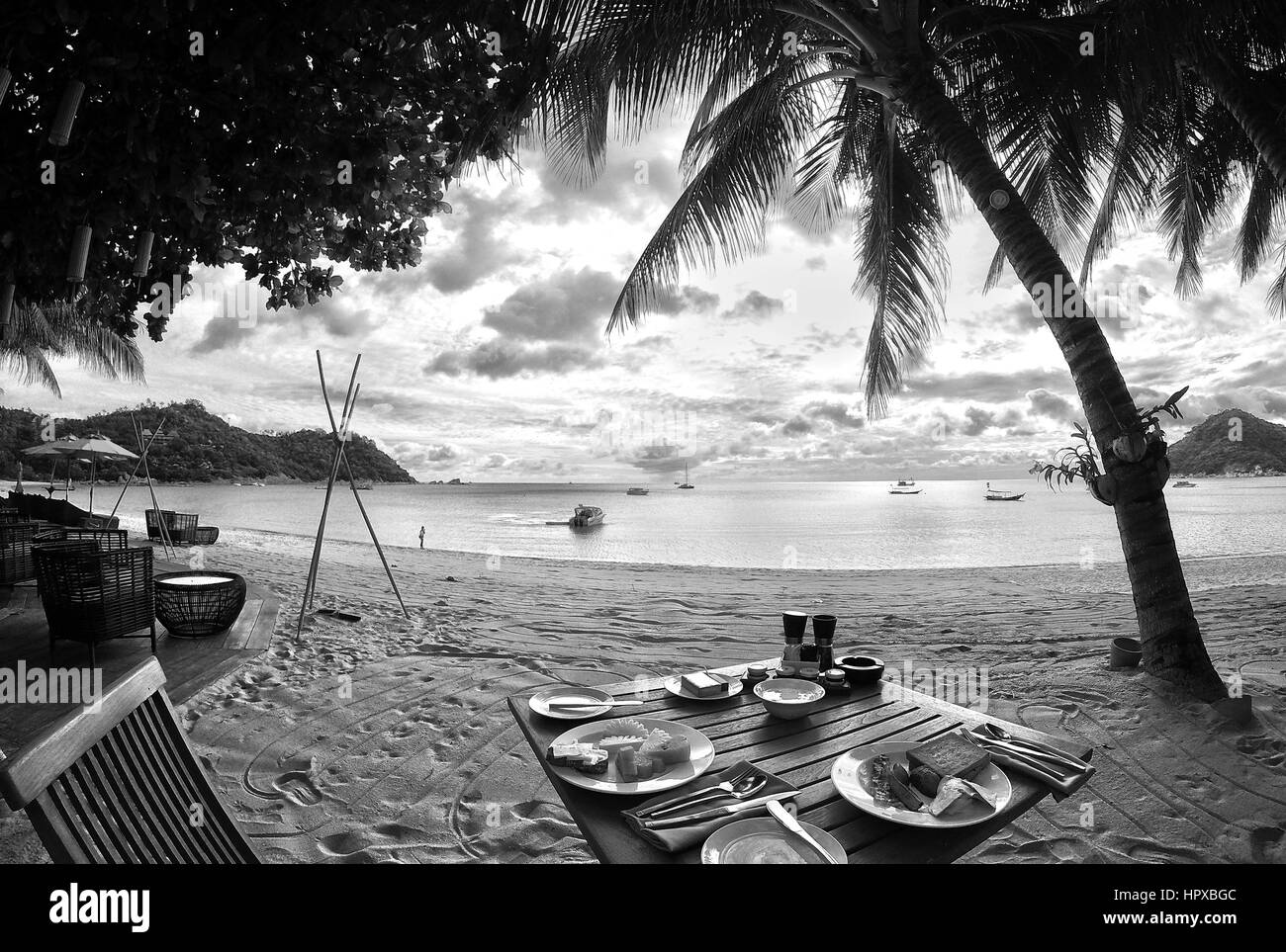 Kaffee Tasse Frühstück am Holztisch bei Sonnenaufgang Strand Koh Phangan Thailand schwarz weiß Stockfoto