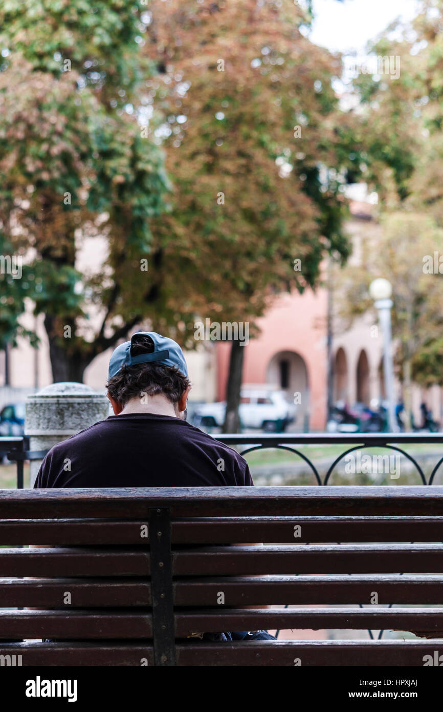 Junger Mann sitzt auf einer Bank an der Universität von Treviso Stockfoto