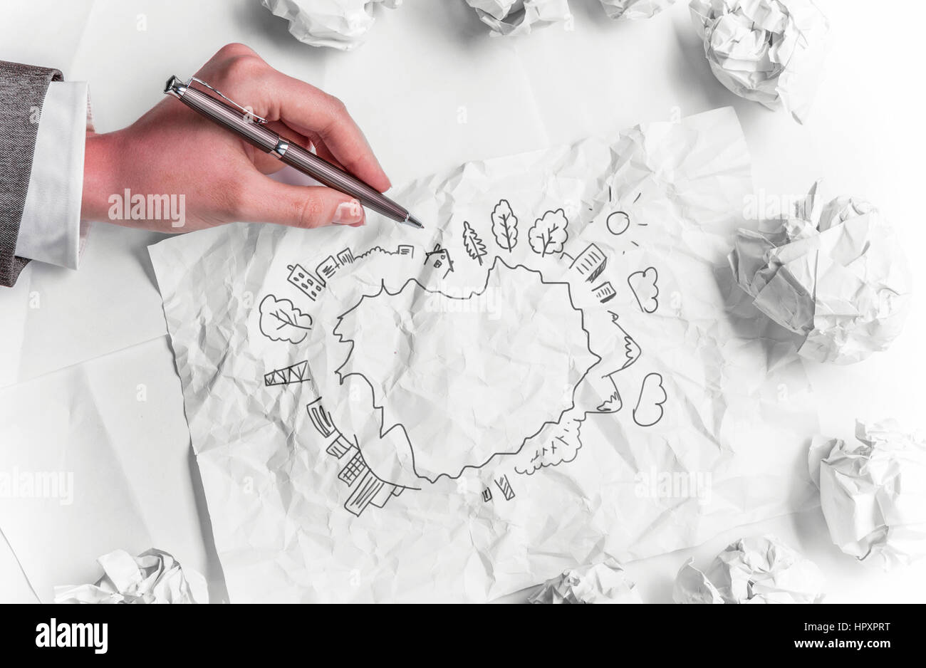 Hand der Geschäftsfrau Zahnräder auf zerknittertes Papier zeichnen Stockfoto