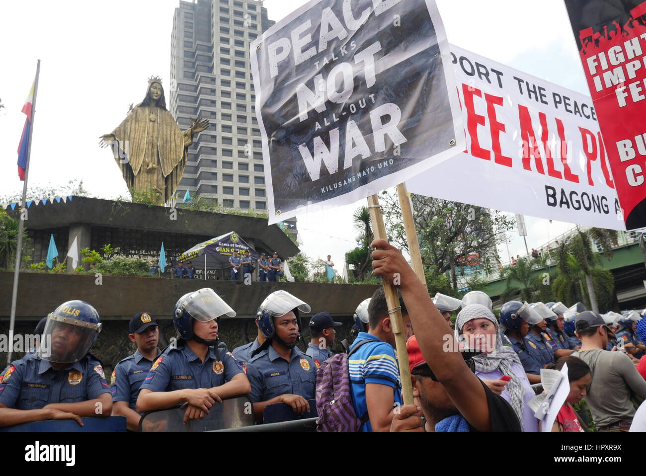 Polizisten bewacht die EDSA Schrein Kapelle als Demonstranten an der Ecke der EDSA und Ortigas Allee montieren. Während der 31. Feier der "Macht des Volkes" in EDSA. Demonstranten versammelt, die gegen die Duterte-Administration sind, die sie denken, dass eine Diktatur wieder auftauchen kann. Aguinaldo. Zuerst montiert auf 09:00-Demonstranten "Block Marcos Bewegung" round up People Power Monument, Stunden später eine größere Menge von Demonstranten in der Ecke der EDSA und Ortigas Allee, wo die EDSA Schrein Kapelle stehend und Marsch in das Hauptquartier der Streitkräfte der Philippinen ist. (Foto b Stockfoto