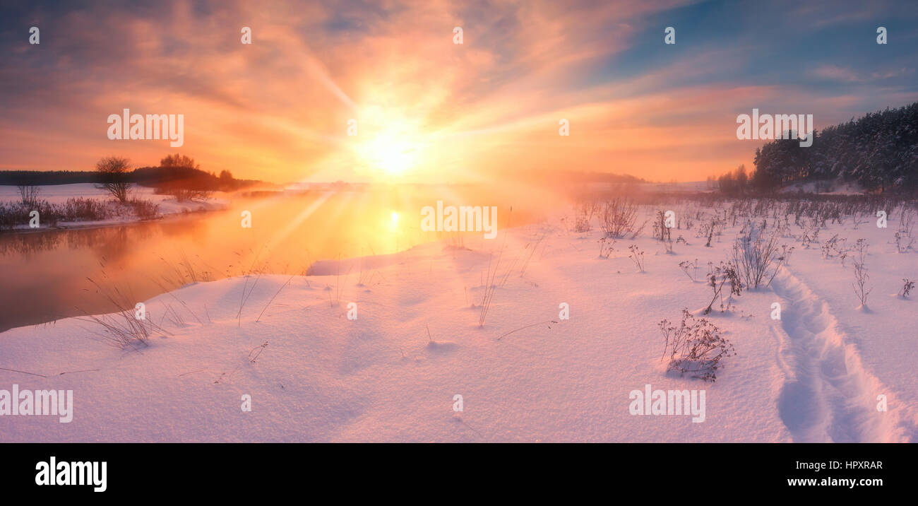 Nebligen Winter Sonnenuntergang bunte Winterabend bei strahlendem Sonnenschein über einen Fluss Stockfoto