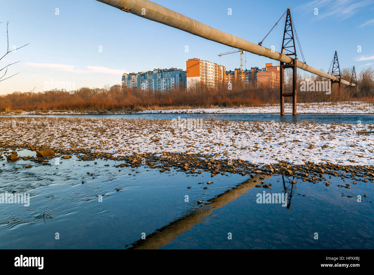 Gas oder Wasser-Leitung über den Fluss und Wohngebäude hinter Stockfoto