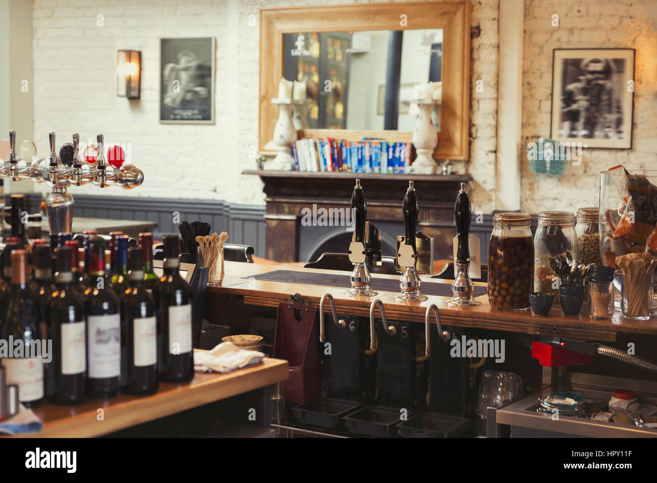 Weinflaschen und tippen Sie auf Griffe hinter Bar in leeren Kneipe Stockfoto