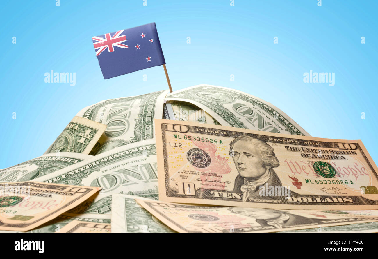 Die Nationalflagge von Neuseeland stecken in einem Haufen von US-Dollar. (Serie) Stockfoto