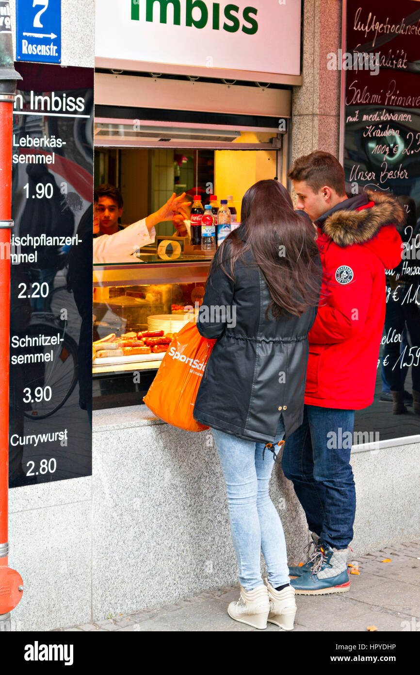 Junges Paar Fast-Food aus einer Straßenseite Shop kaufen München, Oberbayern, Deutschland, Europa Stockfoto