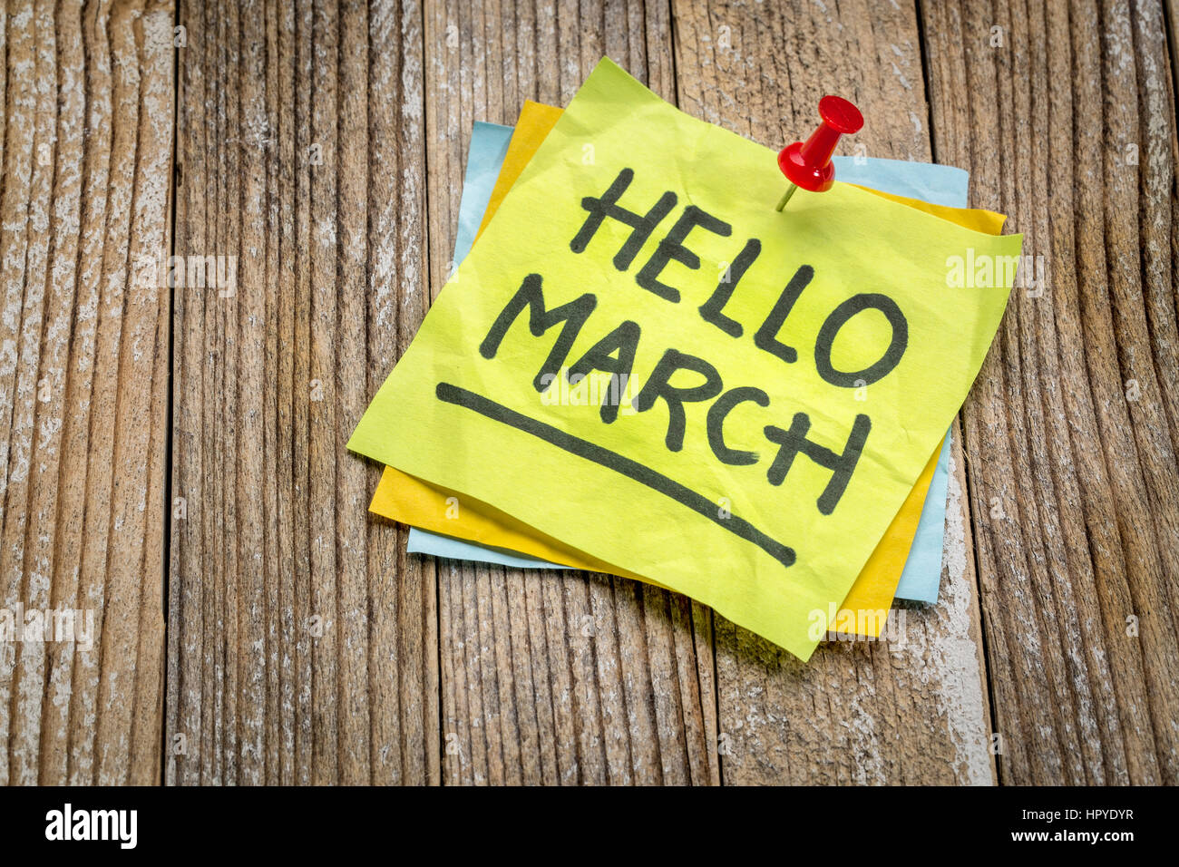 Hallo März Grüße auf einem Zettel gegen Grunge Holzplatte Stockfoto