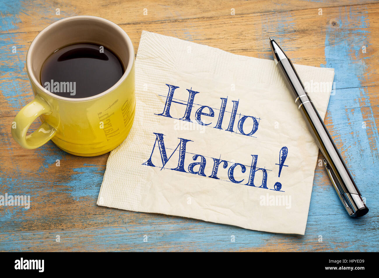 Hallo März - Handschrift auf einer Serviette mit einer Tasse Kaffee Stockfoto
