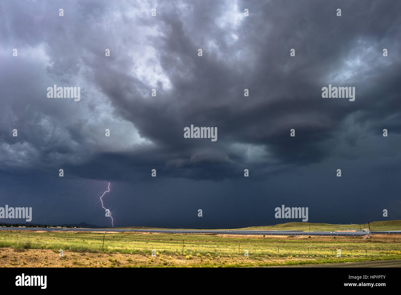 Dunkler stürmischer Himmel mit Blitzen über einem Feld Stockfoto