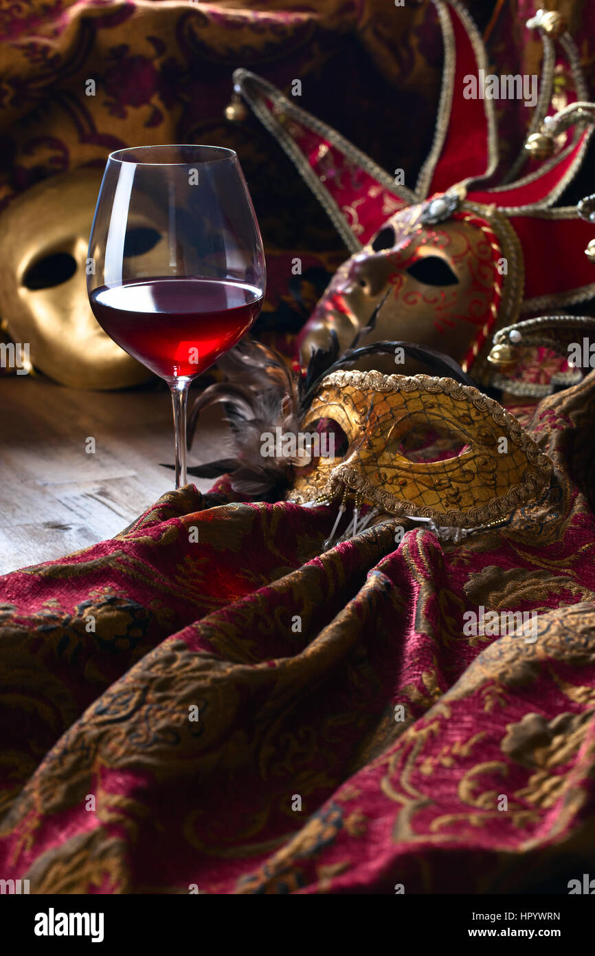 Alte goldene venezianische Masken und Rotwein Stockfoto