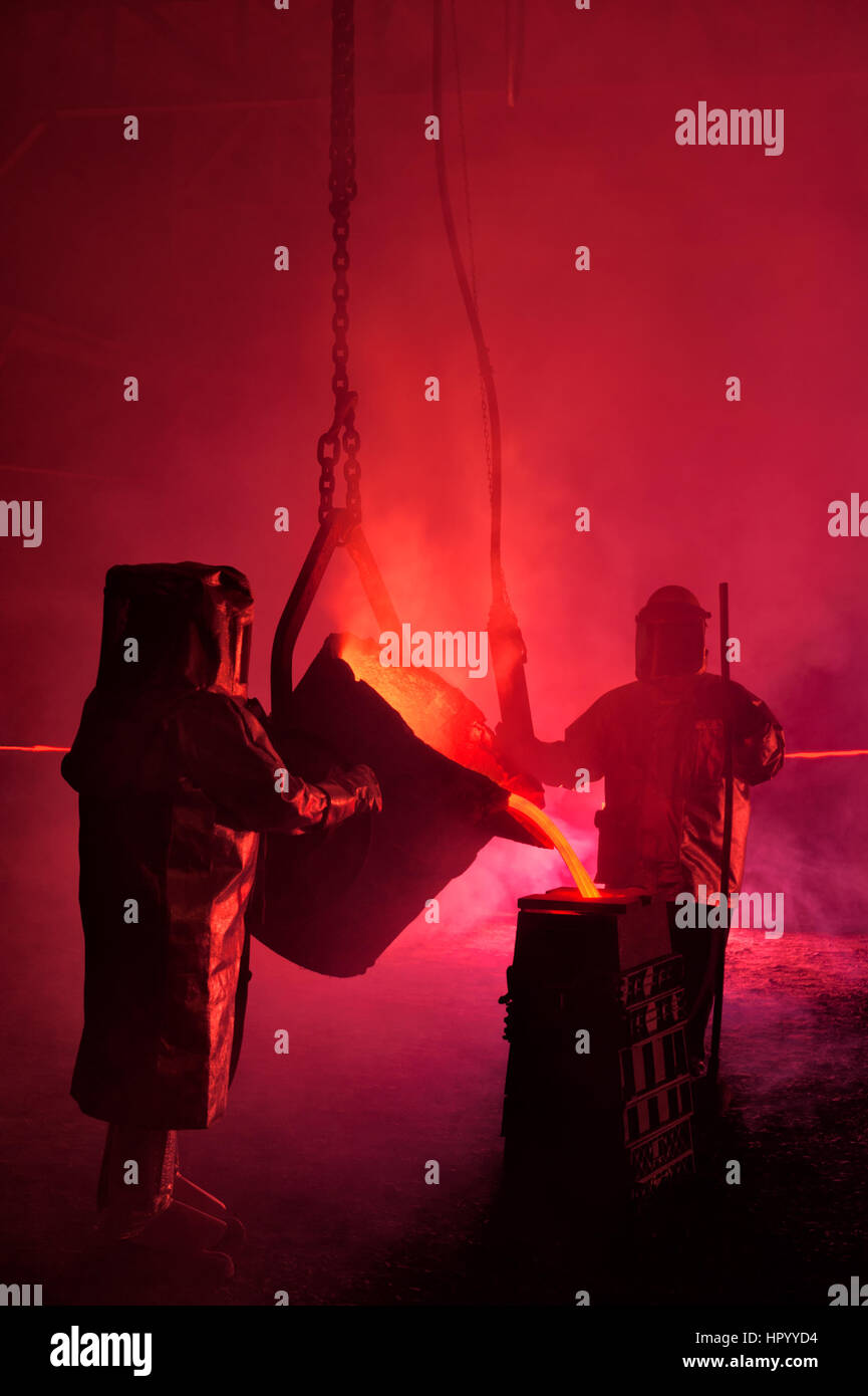 Gießt geschmolzenes Eisen in einem Stahlwerk Reenactment, metallurgische Arbeitnehmer mit Schöpflöffel Löffel, heiß, rauchig, und gefährlich, Bethlehem, Pennsylvania, USA. Stockfoto