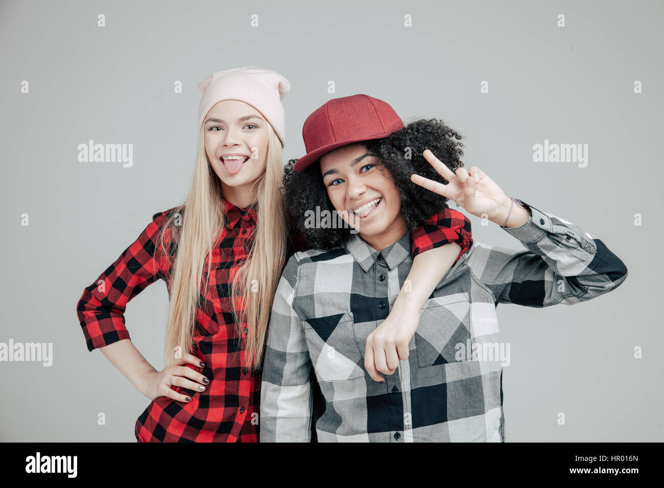 Lebensstil Studioportrait von zwei beste Freunde Hipster-Mädchen tragen stilvolle helle Outfits, verrückt und tolle Zeit zusammen. Isoliert auf wh Stockfoto