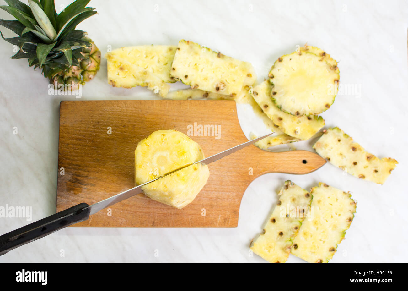 Messer schneiden Ananas auf einem Holzbrett Stockfoto