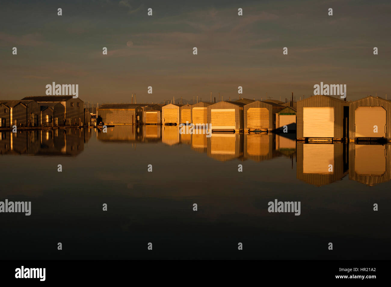 Bootshaus Reflexionen in Reihen entlang der Uferpromenade am Everett Marina mit mondaufgang. Stockfoto
