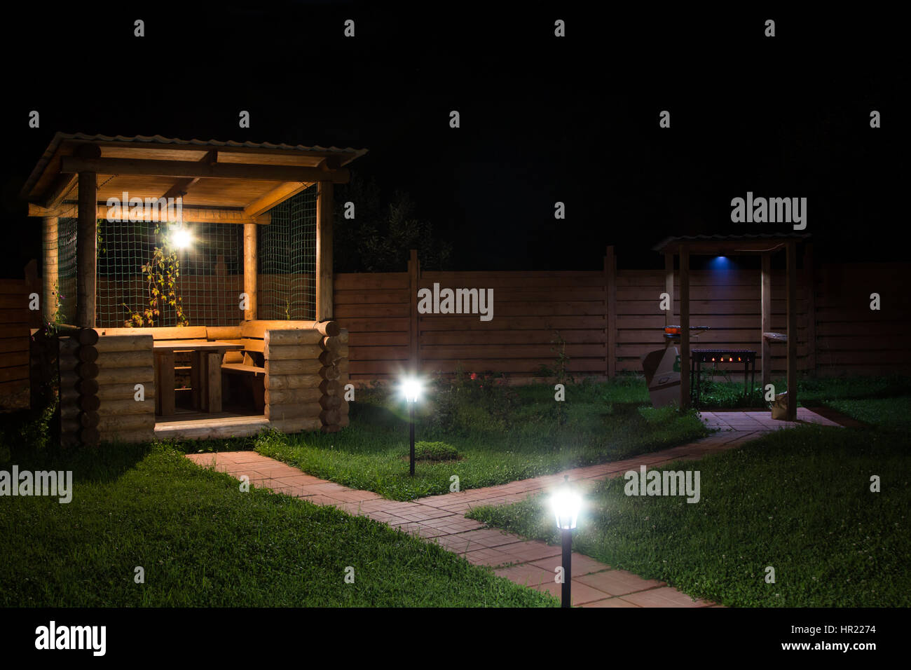 Laube und Grill im Garten in der Nacht Stockfoto