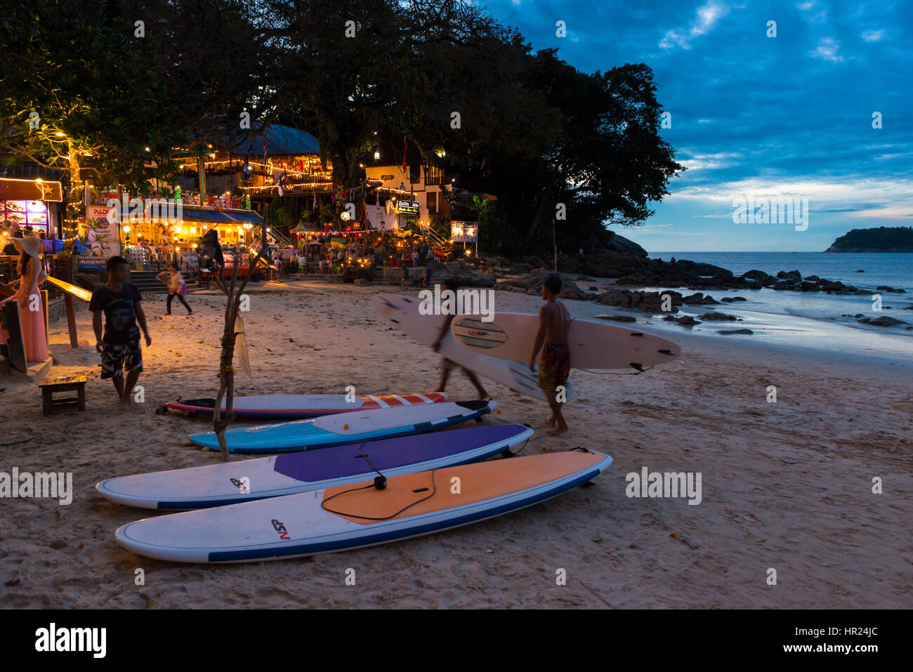 Surfer, die nachts mit Surfbrettern auf dem Rent-Shop am Kata Beach, Phuket, Thailand Stockfoto