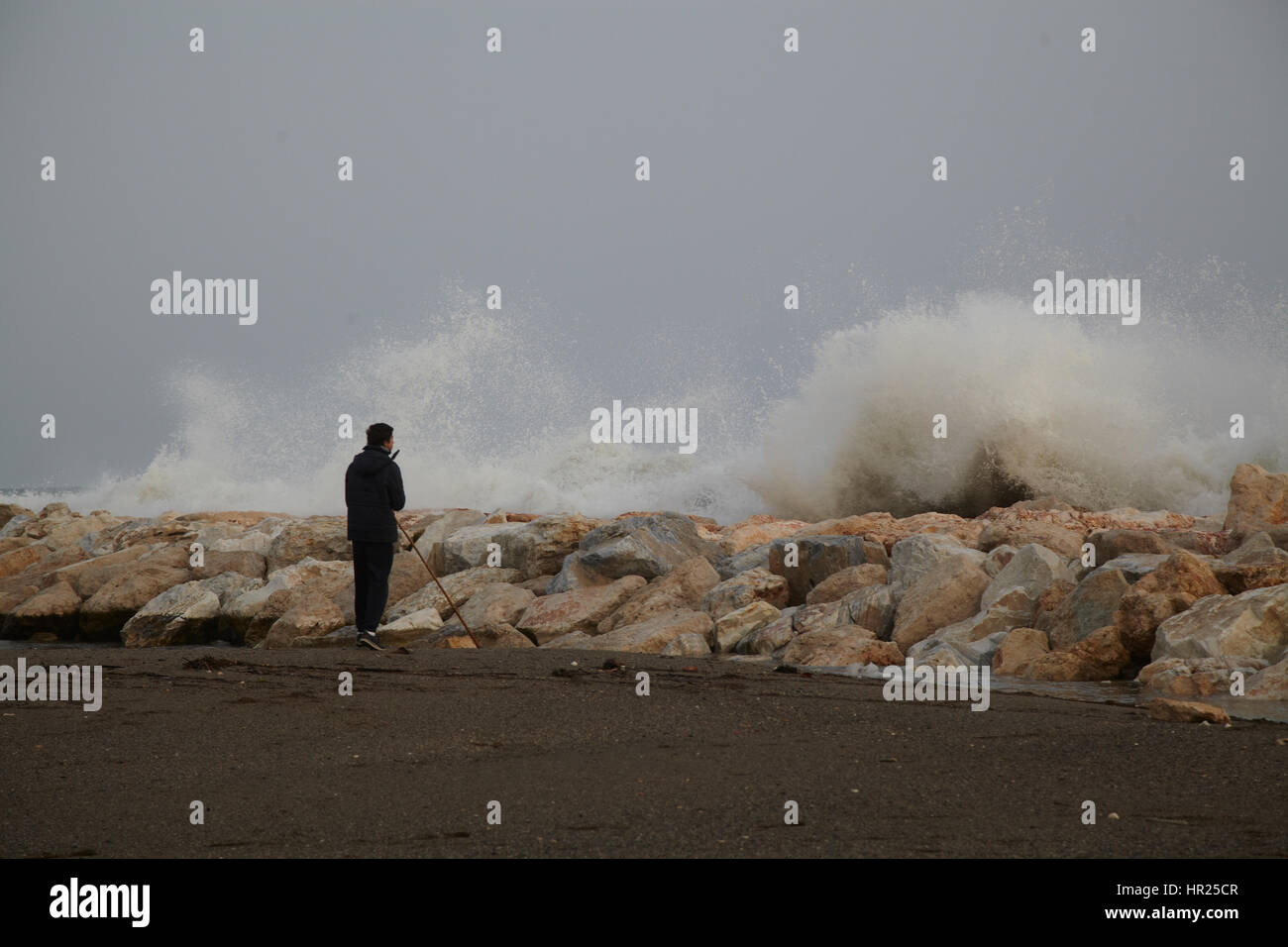 Ein Junge auf der Suche trifft eine große Welle einen Wellenbrecher. Malaga. Spanien Stockfoto