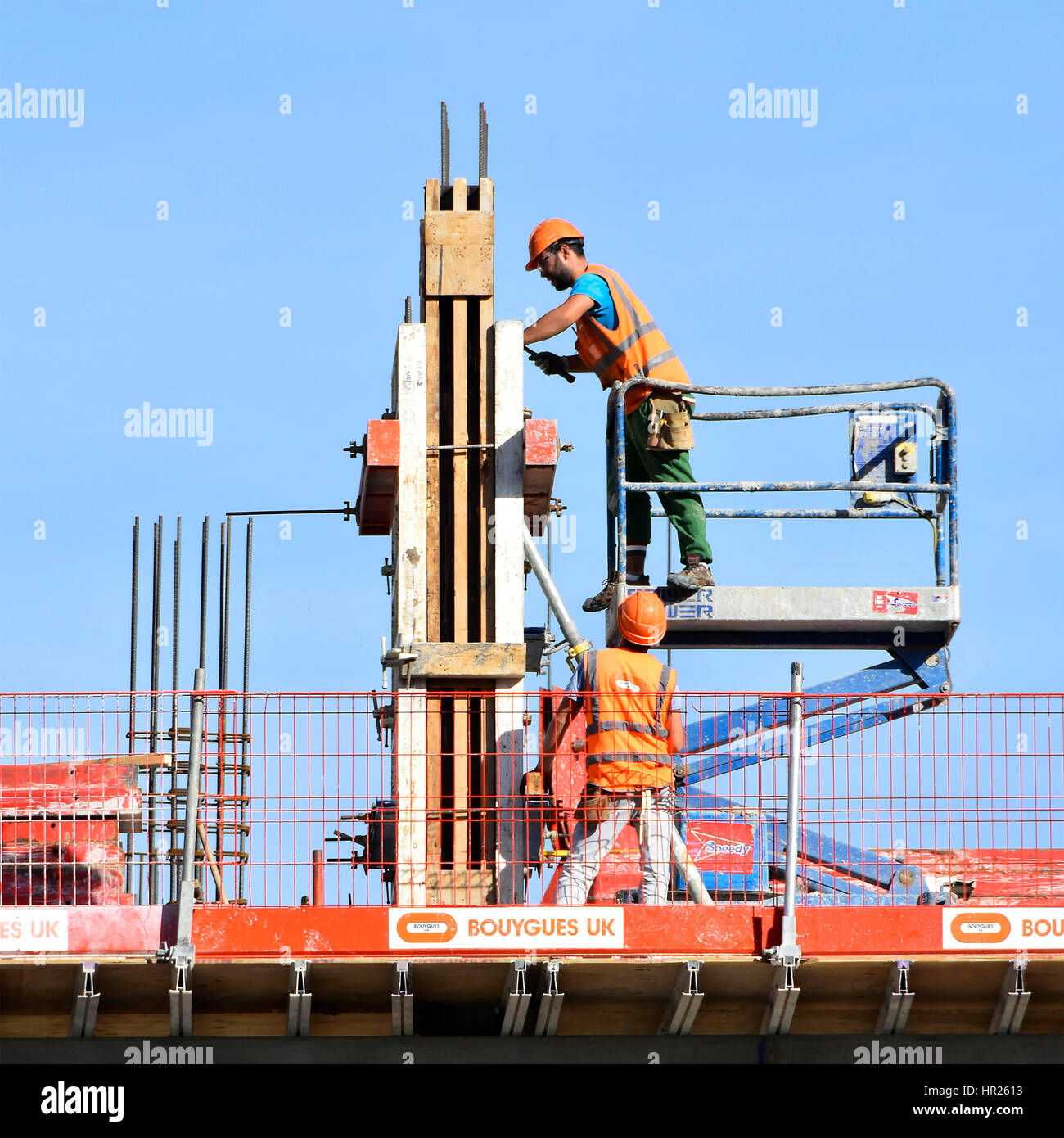 Gesundheit und Sicherheit, die Bauarbeiter Bau Website Befestigung Spalte Schalung gemeinsam Arbeitshelme & Warnschutz Jacke an Hochhaus Stockfoto
