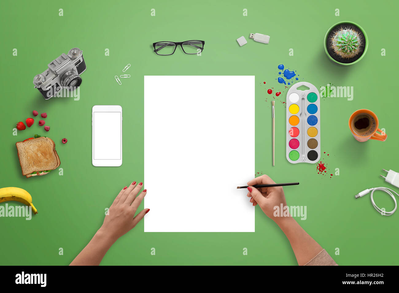 Mädchen auf einem leeren weißen Papier mit Pinsel und Wasser Farben malen. Draufsicht der grünen Schreibtisch. Stockfoto