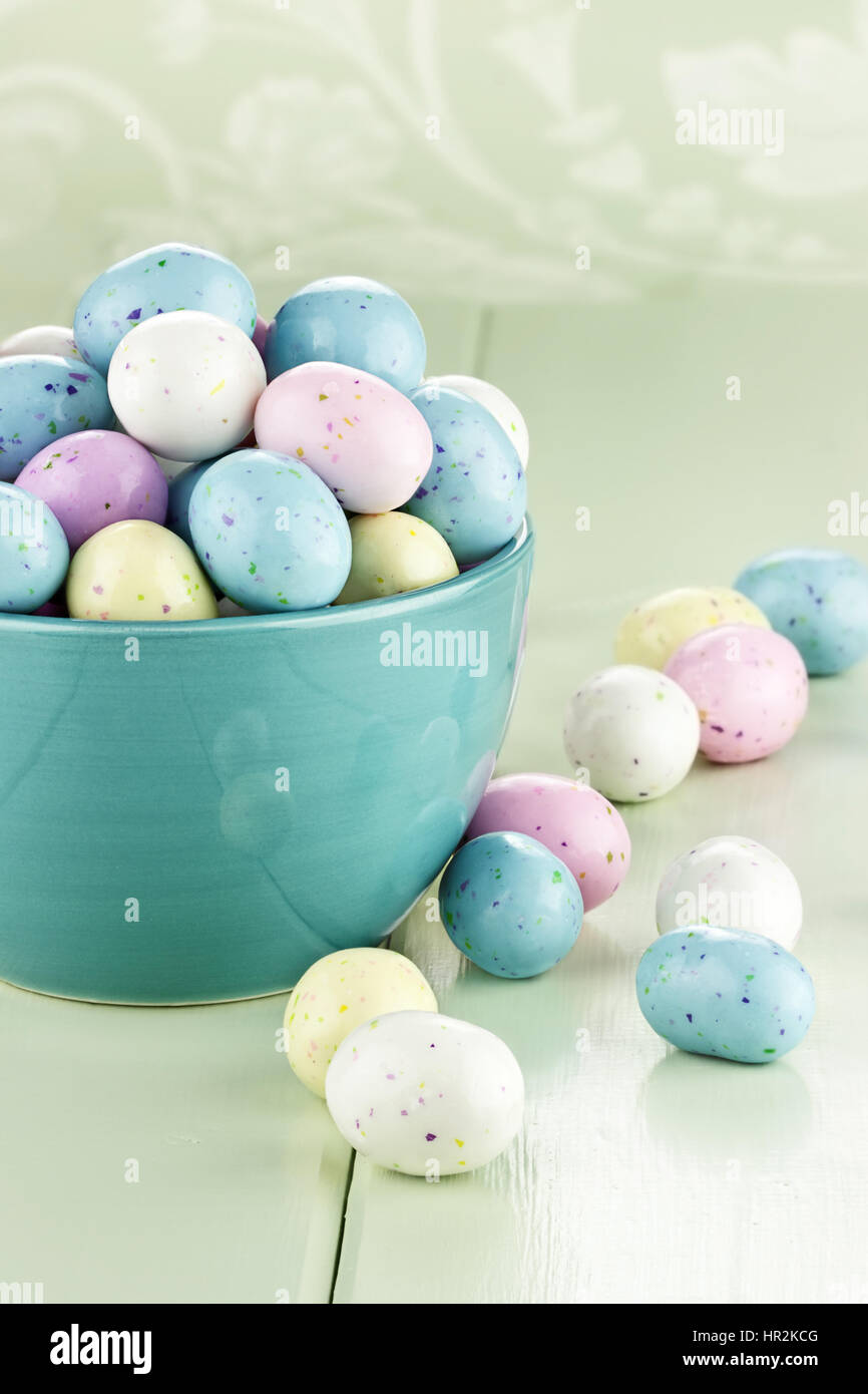 Eine blaue Schale gefüllt mit gesprenkelten Ostereier Süßigkeiten. Geringe Schärfentiefe. Stockfoto
