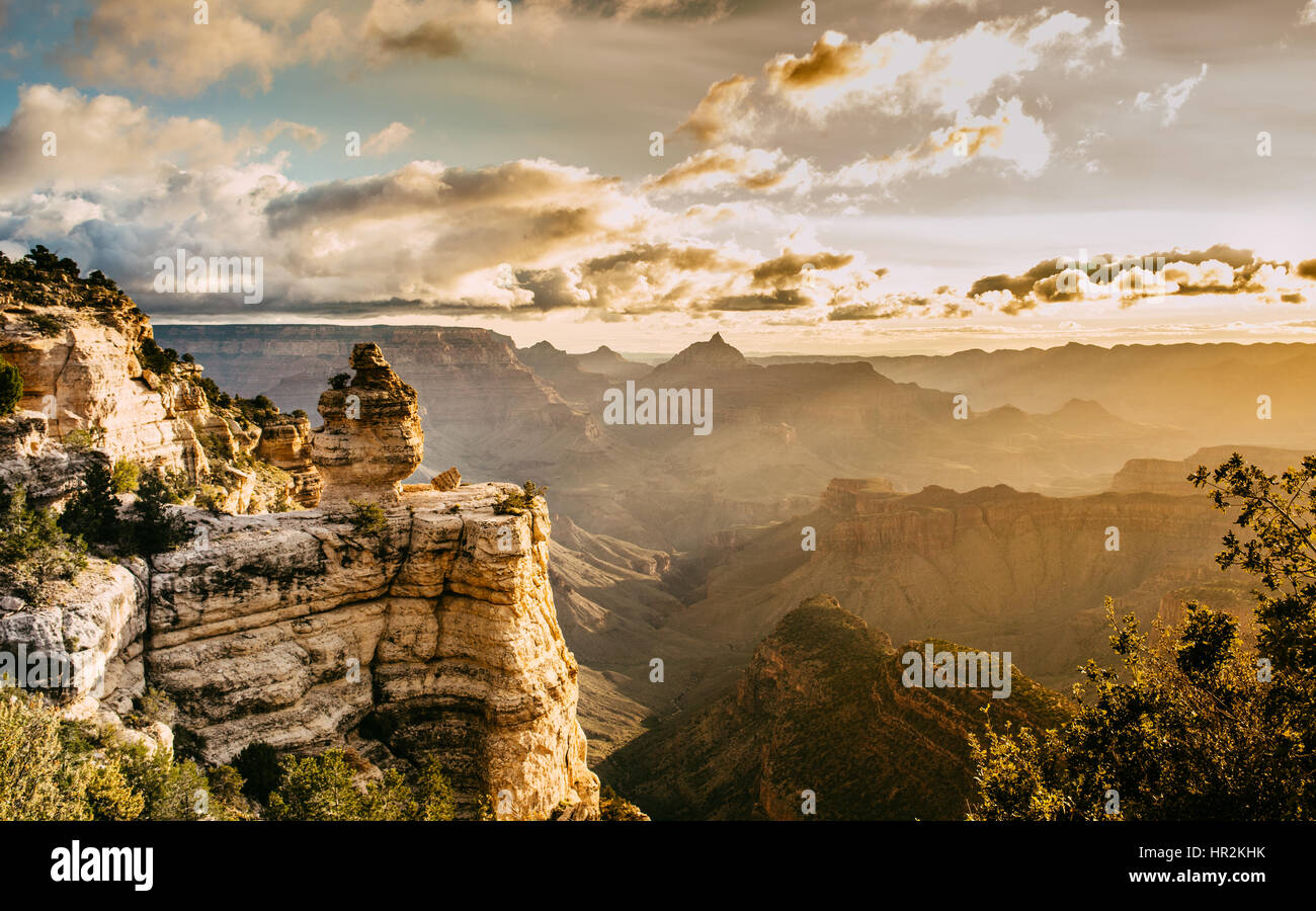 Gebirge in den Grand Canyon mit orange Sonnenstrahlen auf dem Lande, mit einigen Wolken am Himmel Stockfoto