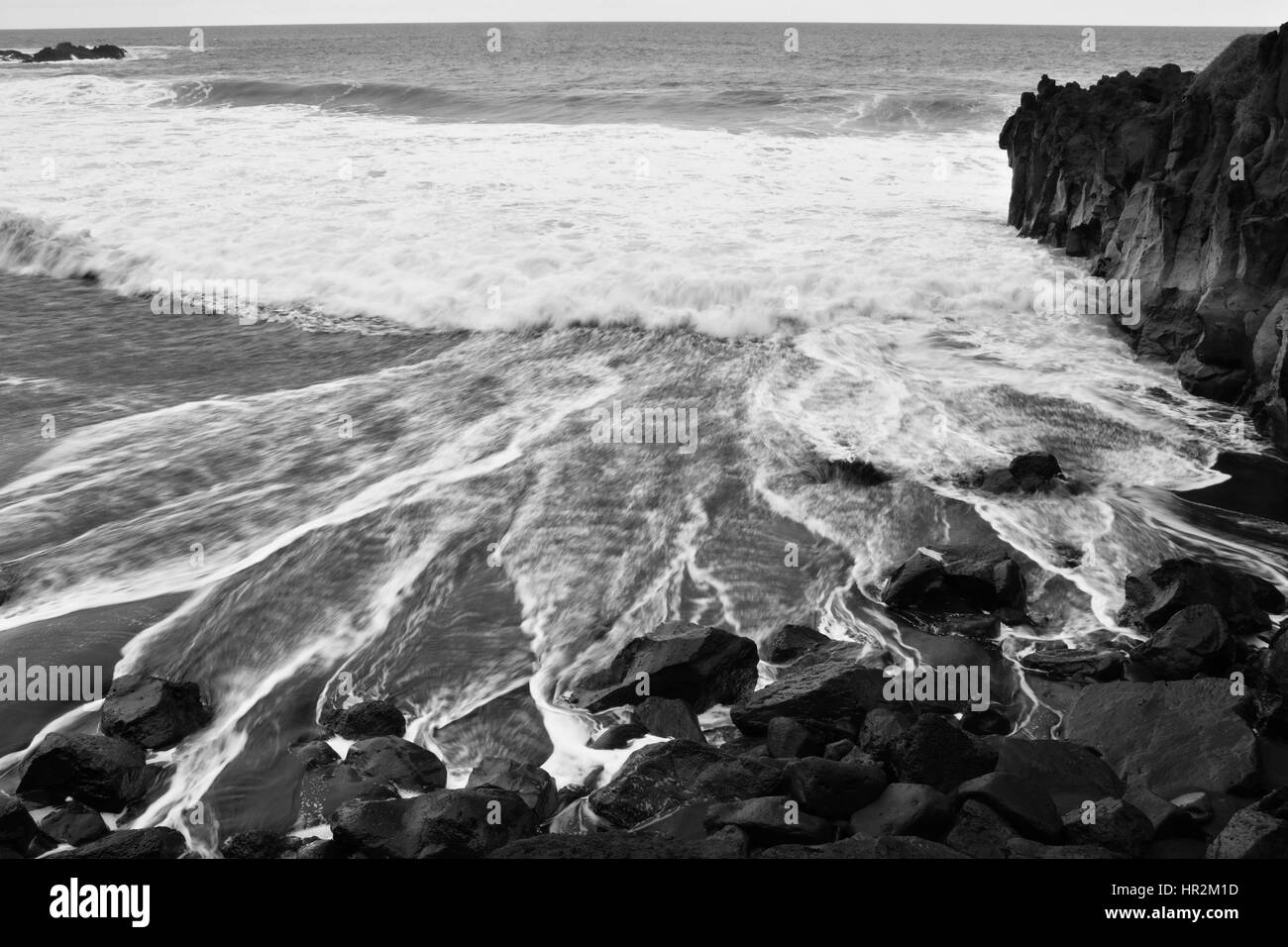 Schwarze Felsen Vulkan-Strand und Schaum aus einer Welle, schwarz / weiß Bild von Teneriffa. Stockfoto