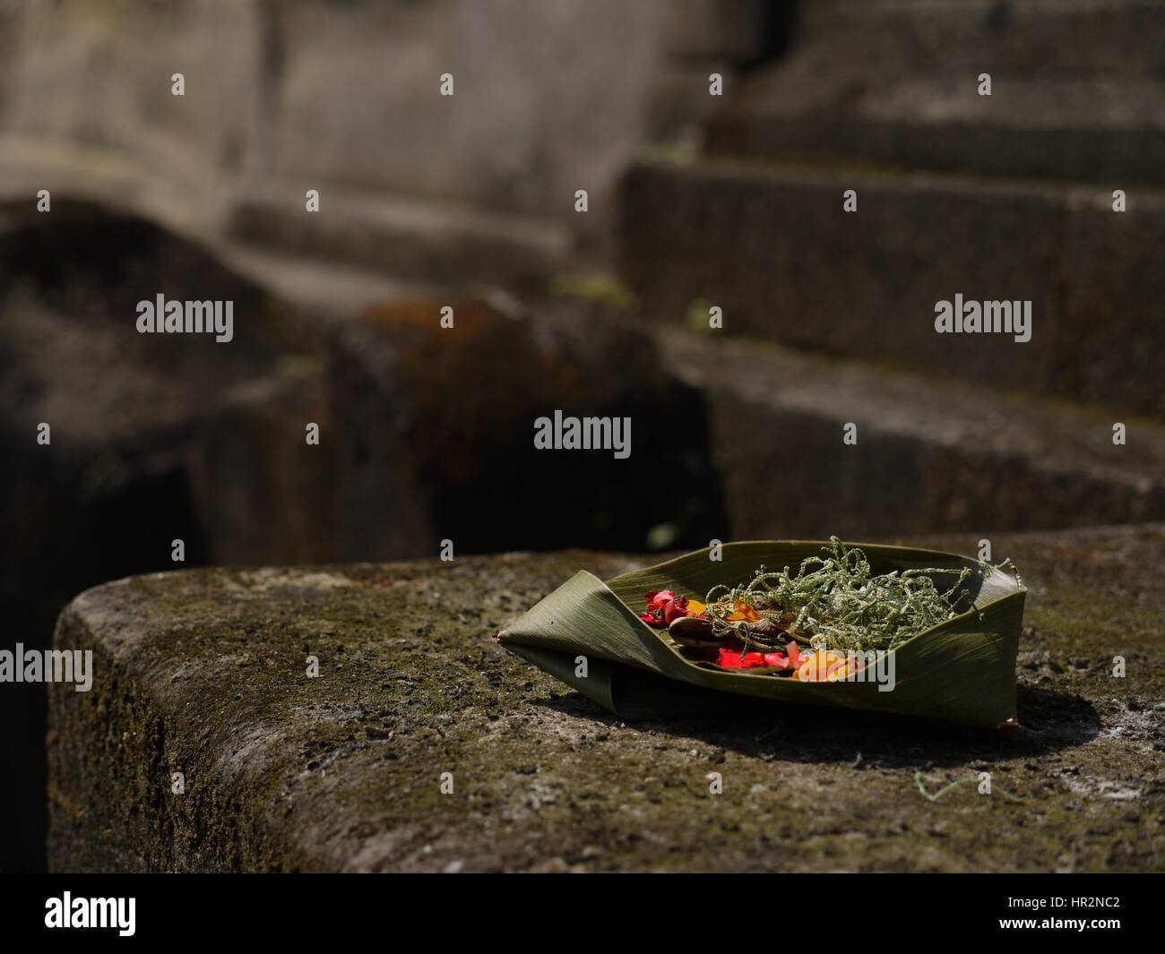 Balinesischen traditionellen Opfergabe für Götter und Geister liegen auf Steinen der alten Tempel. Bali, Indonesien Stockfoto