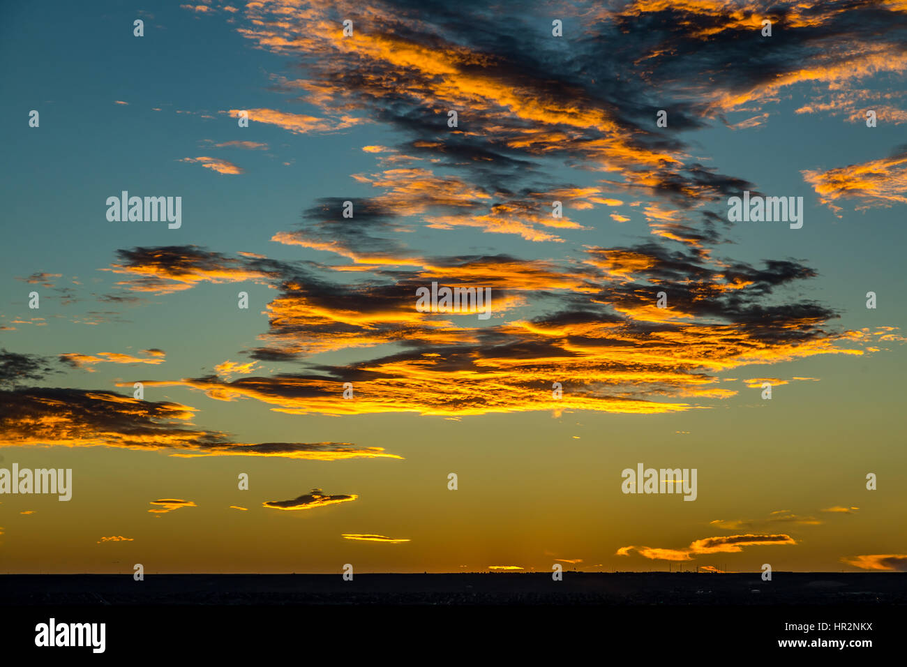 Die Sonne geht über Albuquerque in New Mexico Beleuchtung Wolken am Himmel von unterhalb. Stockfoto