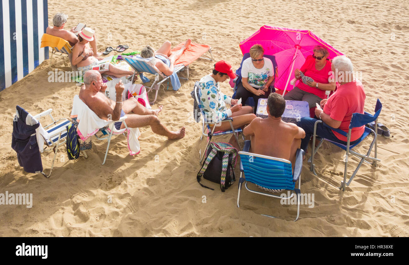 Ältere Menschen entspannen und Spielkarten am Strand. Playa de Las Canteras, Las Palmas, Gran Canaria, Kanarische Inseln, Spanien. Stockfoto