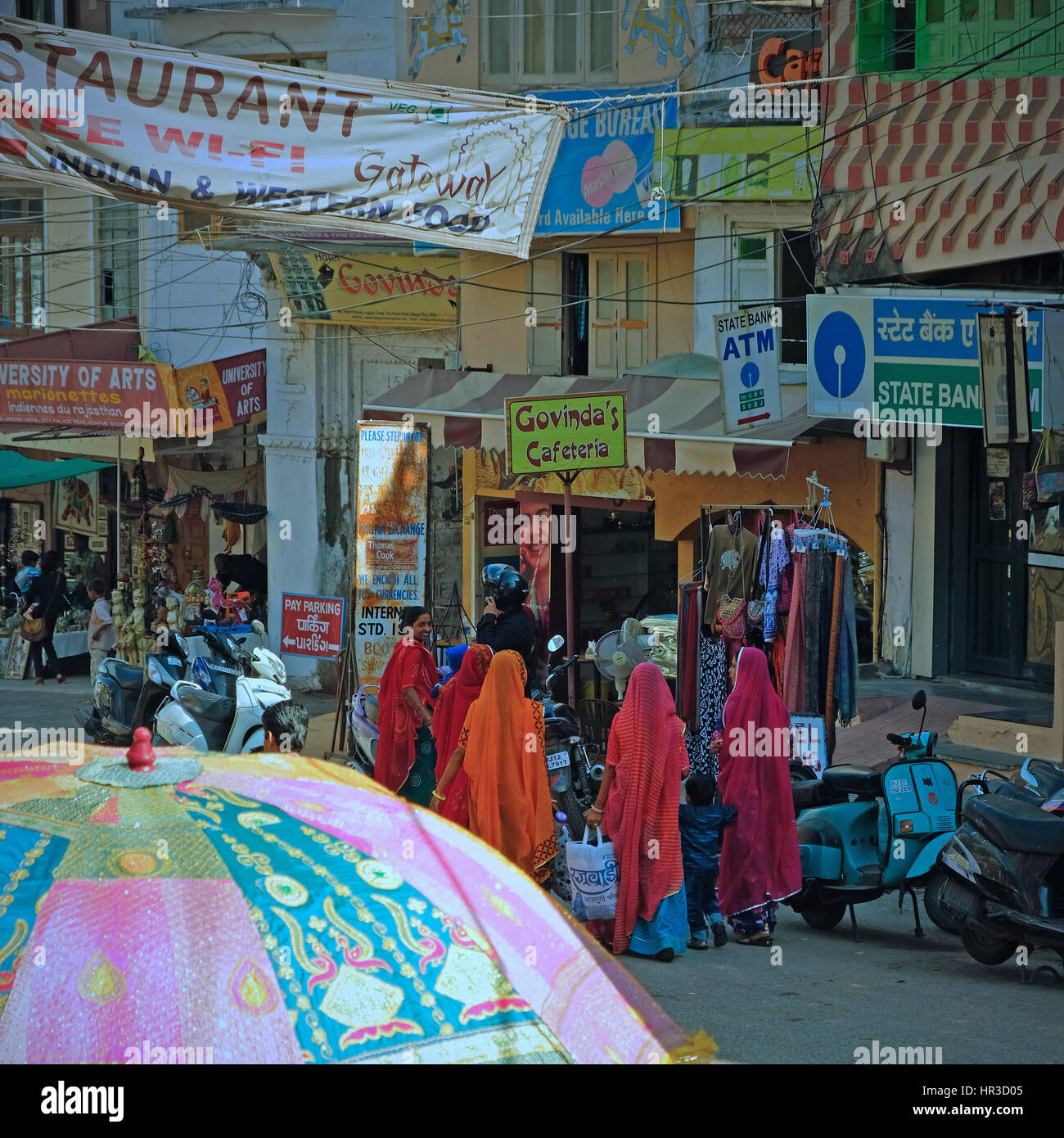 Frauen in typisch bunten Rajasthani-Kleid im Gespräch auf dem belebten Markt von Udaipur, Indien Stockfoto