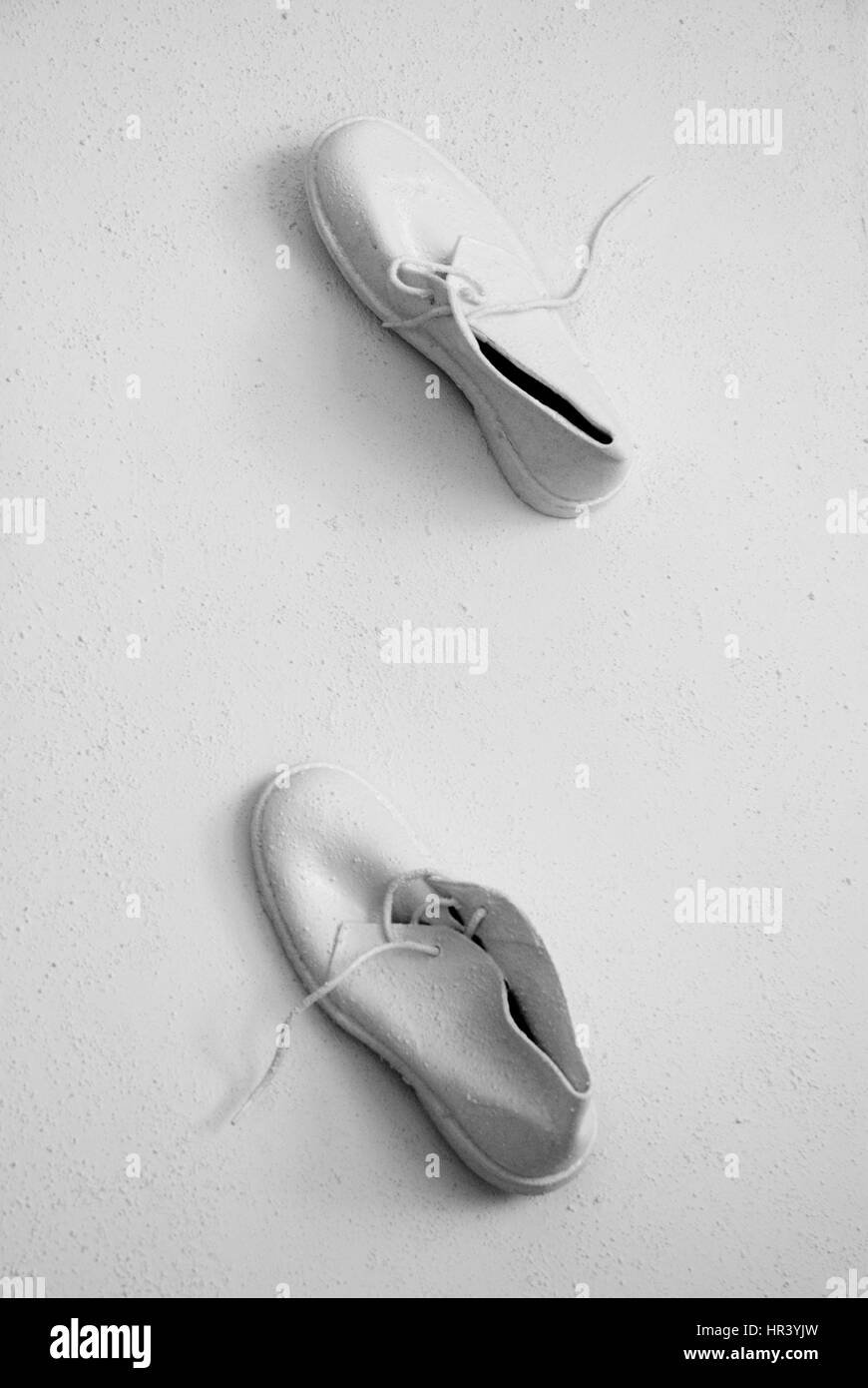 Weiße Schuhe zu Fuß an der Wand. Konzeptionelle und abstrakte Bild Stockfoto