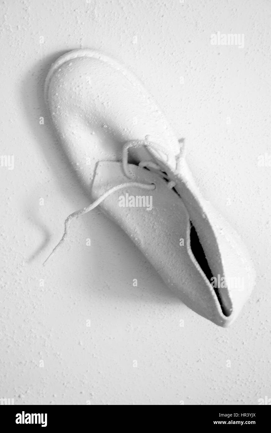 Weiße Schuhe zu Fuß an der Wand. Konzeptionelle und abstrakte Bild Stockfoto